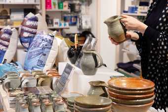 a person holds some pottery in the tate st ives shop